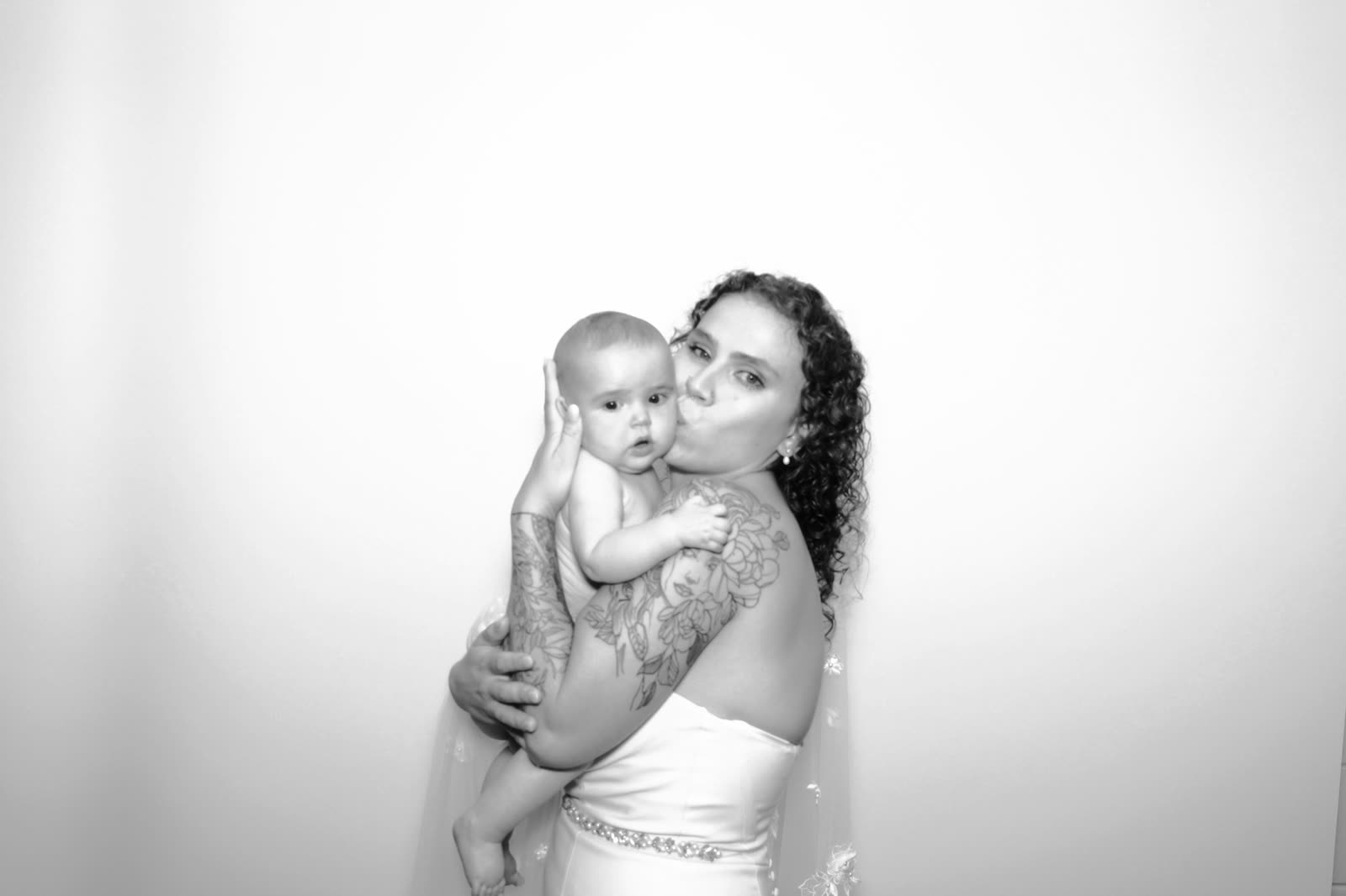 A mother kissing her baby in the booth